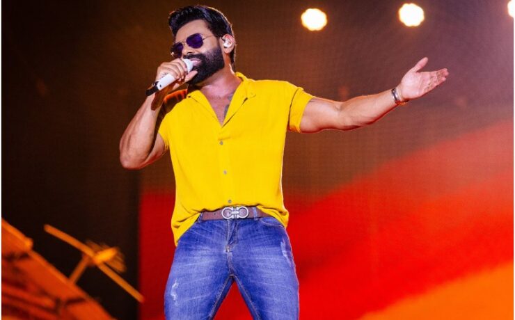O cantor Pablo canta com óculos escuros e camiseta amarela